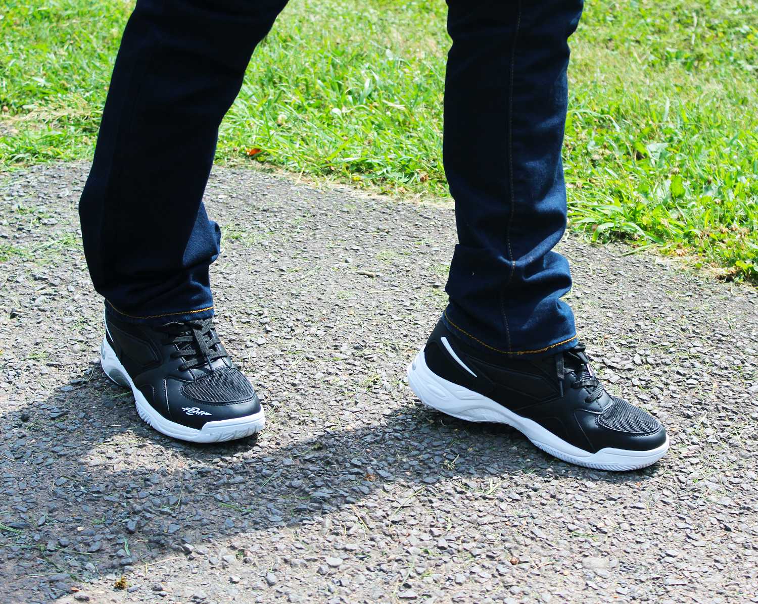 Pair of men’s black walking shoes with white midsoles and lace-up uppers