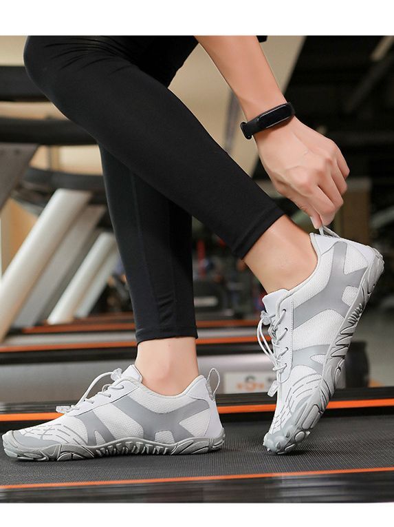 White hiking shoes with lace-up closure and textured outsole, worn on treadmill steps