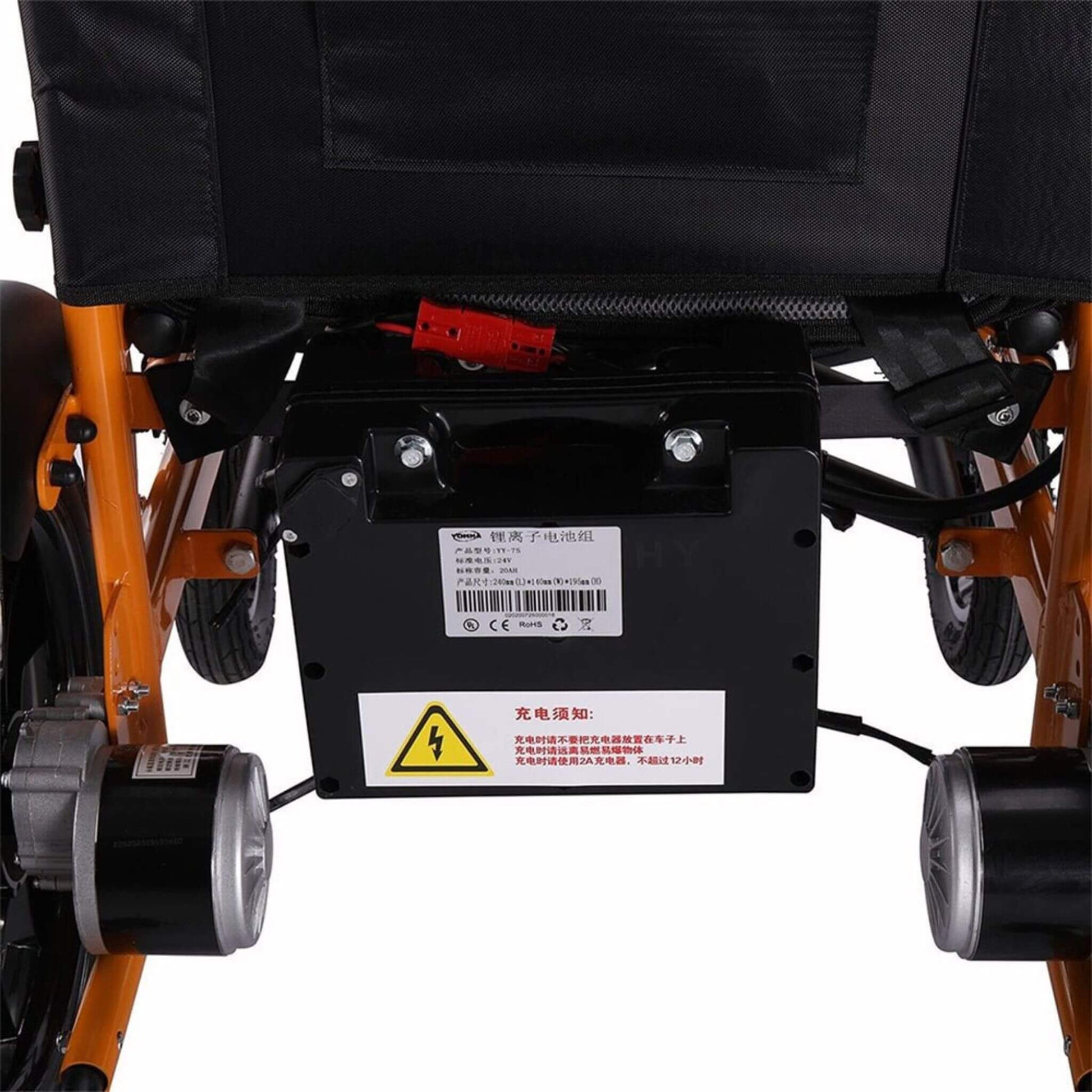 Under-seat battery housing and wiring on orange electric wheelchair frame, warning label