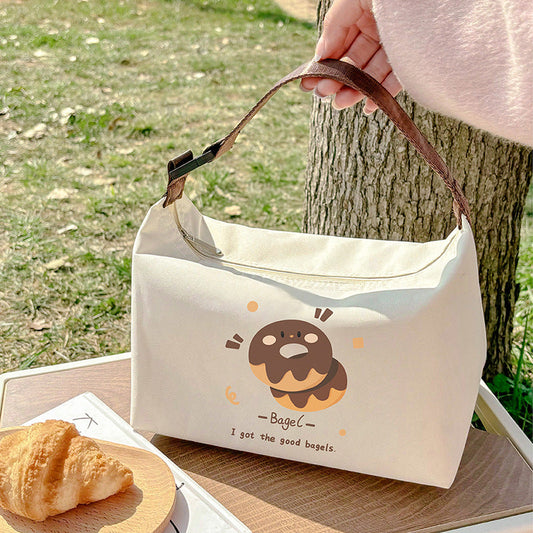 Insulated lunch bag in off-white with brown cartoon bagel face and small graphic icons