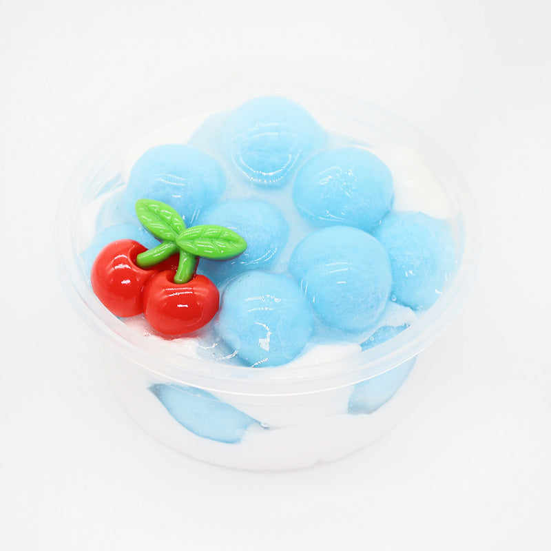 Blue slime cup with red cherry-like candies and green leaf topper