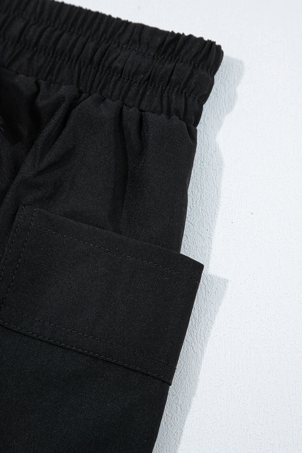 Black active skort close-up: elastic waistband and front pocket panel