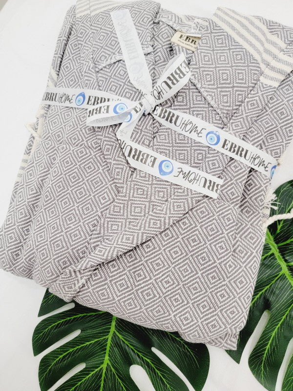 Gray geometric robe fabric close-up with tie straps and attached label tags