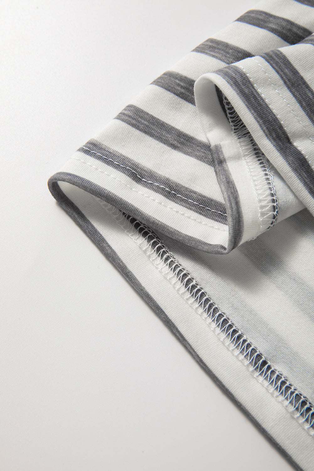 Gray-and-white striped sleeveless jumpsuit fabric and seam detail at hem