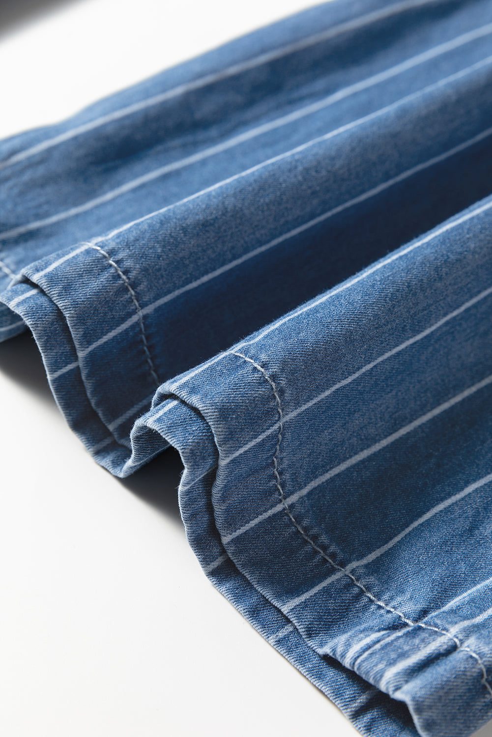 Blue pinstripe denim hem with stitched edge and gathered elastic waist cuff