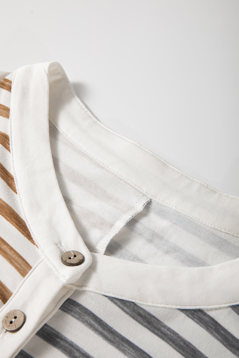 Sleeveless jumpsuit with white scoop neckline, front buttons, and gray stripe panels
