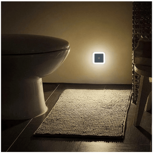 Wall-mounted motion sensor light emitting warm glow from a square LED unit