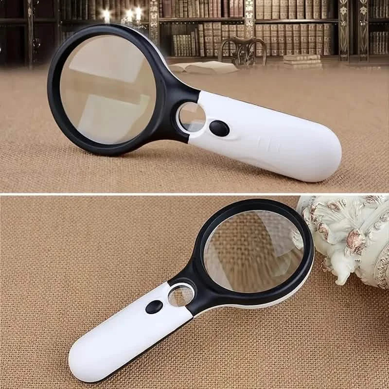 White and black handheld LED magnifier laying on tabletop