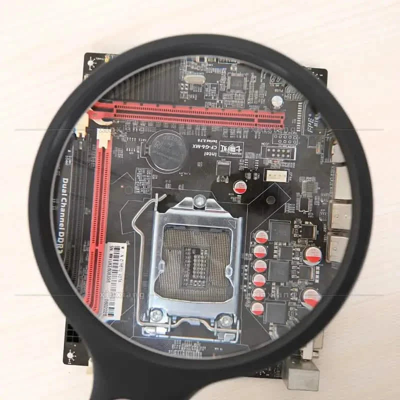 Handheld magnifier viewing a computer circuit board under the lens