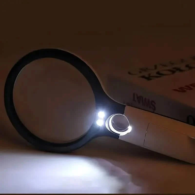 Handheld LED magnifier with illuminated lens ring on white and black body