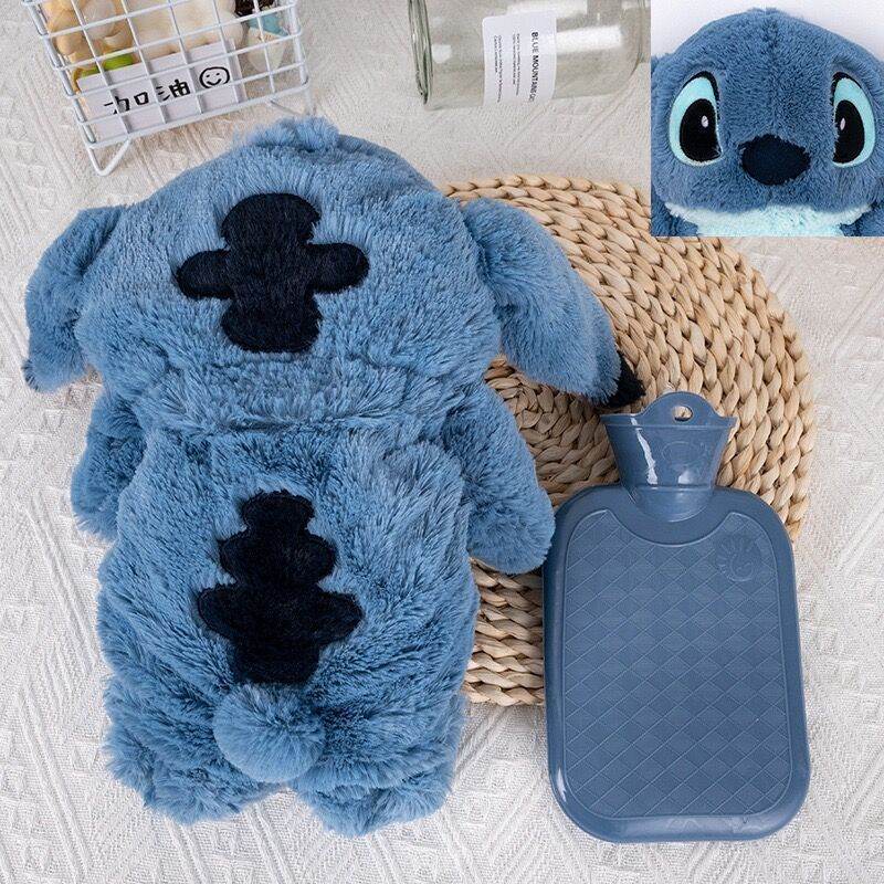 Blue plush cartoon hot water bottle with monster face, blue bottle and cap beside it
