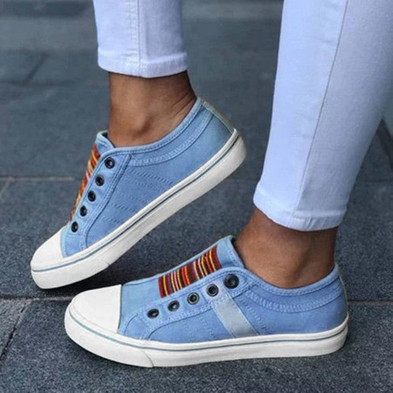 Light blue canvas round-toe sneakers with elastic gore and rainbow stripe detail, white sole