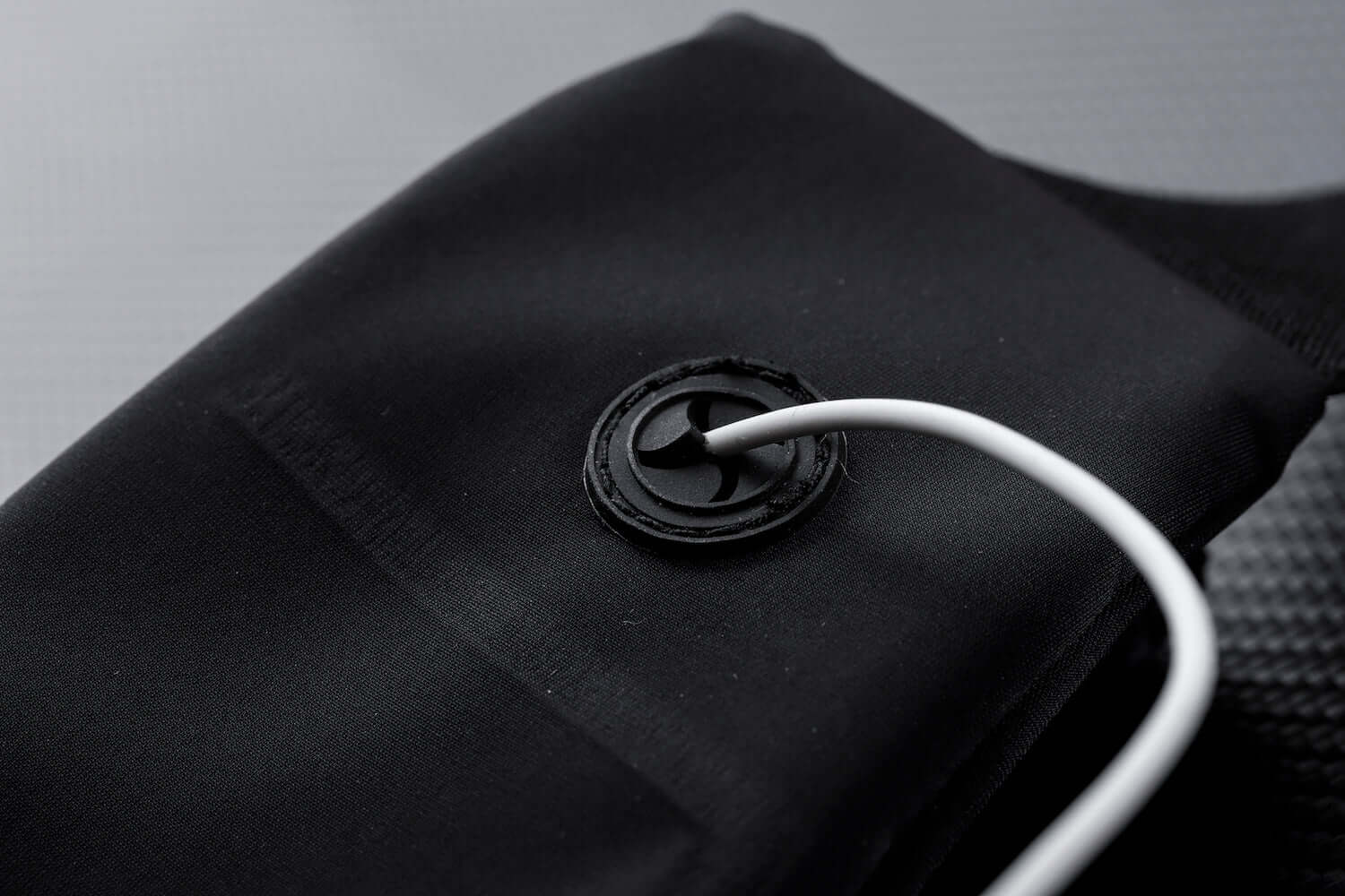 Water-resistant sport waist pack belt, black close-up of attachment ring and cord.
