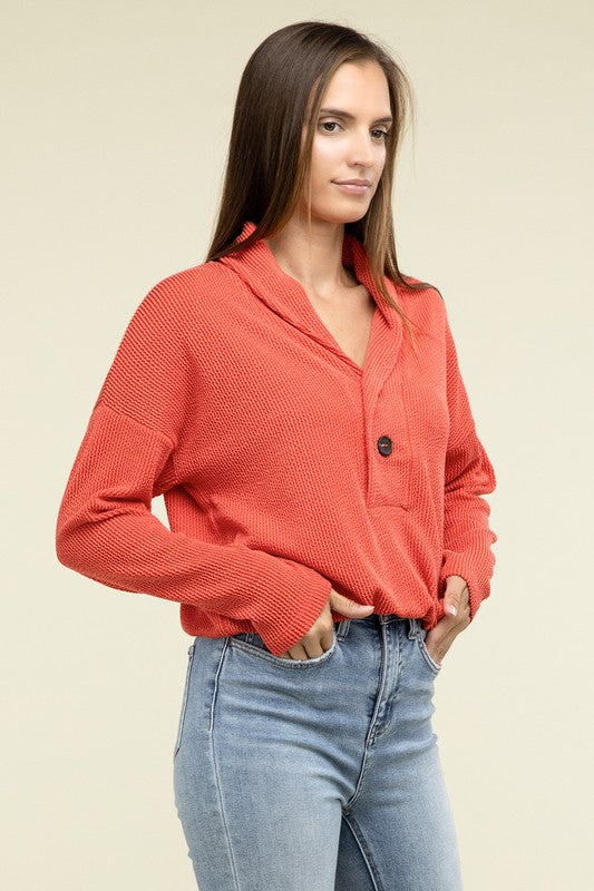 Tomato textured pullover top with V-neck, button placket, chest pocket, long sleeves