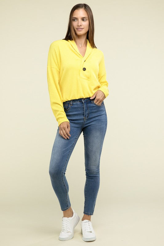 Yellow textured pullover top with V-neck and button closure, chest pocket, elastic waist