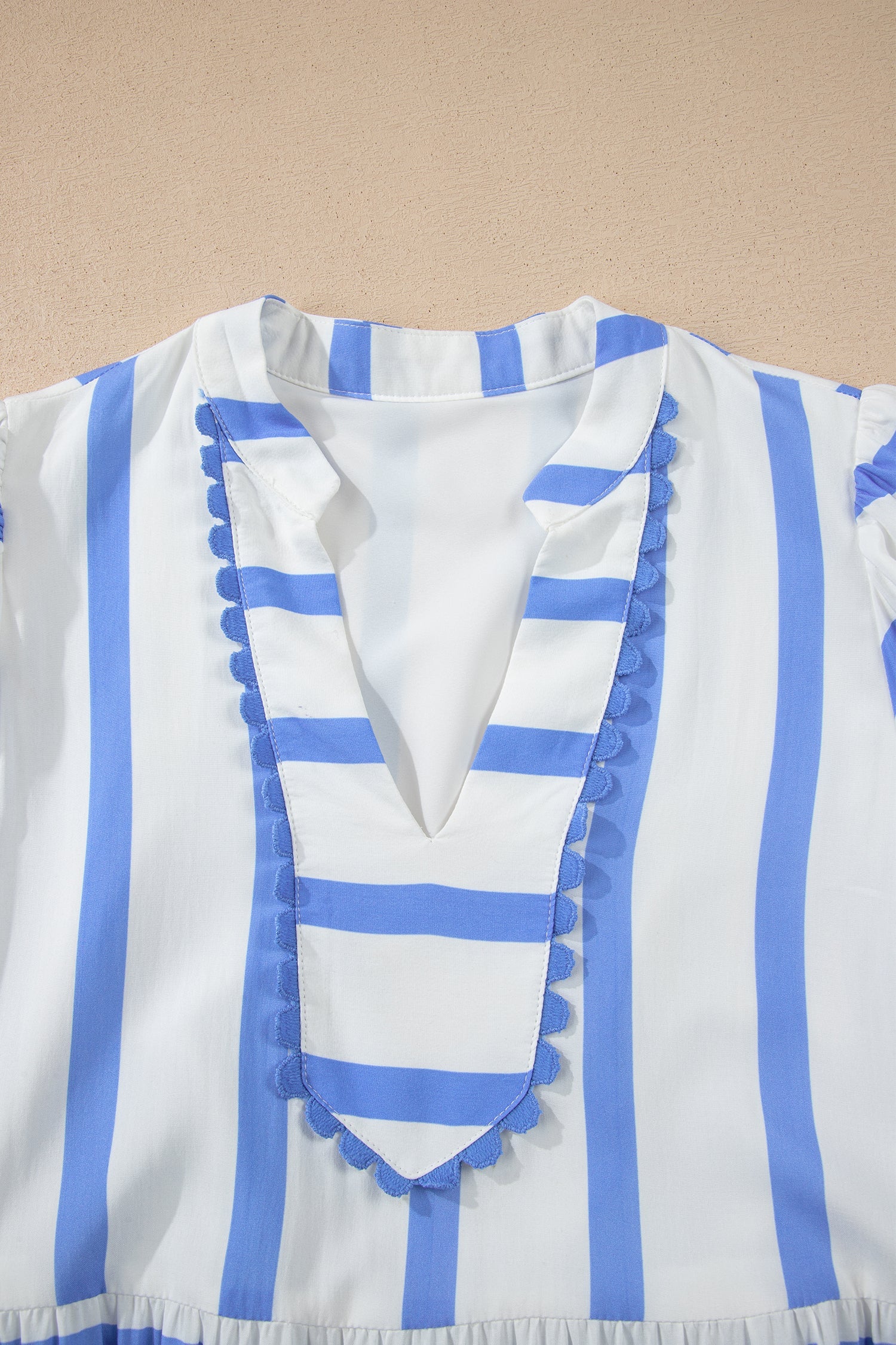 Blue-and-white striped half-sleeve dress with V-neck and ruffled trim at neckline