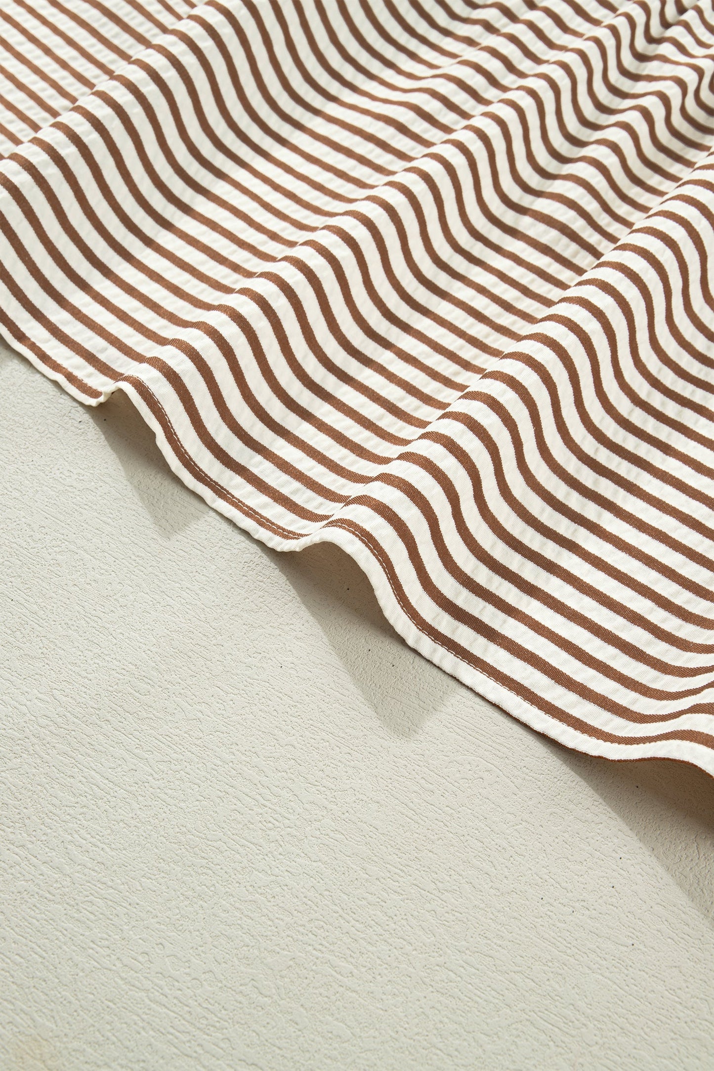 Brown-and-cream striped dress with rounded hem and stitched trim