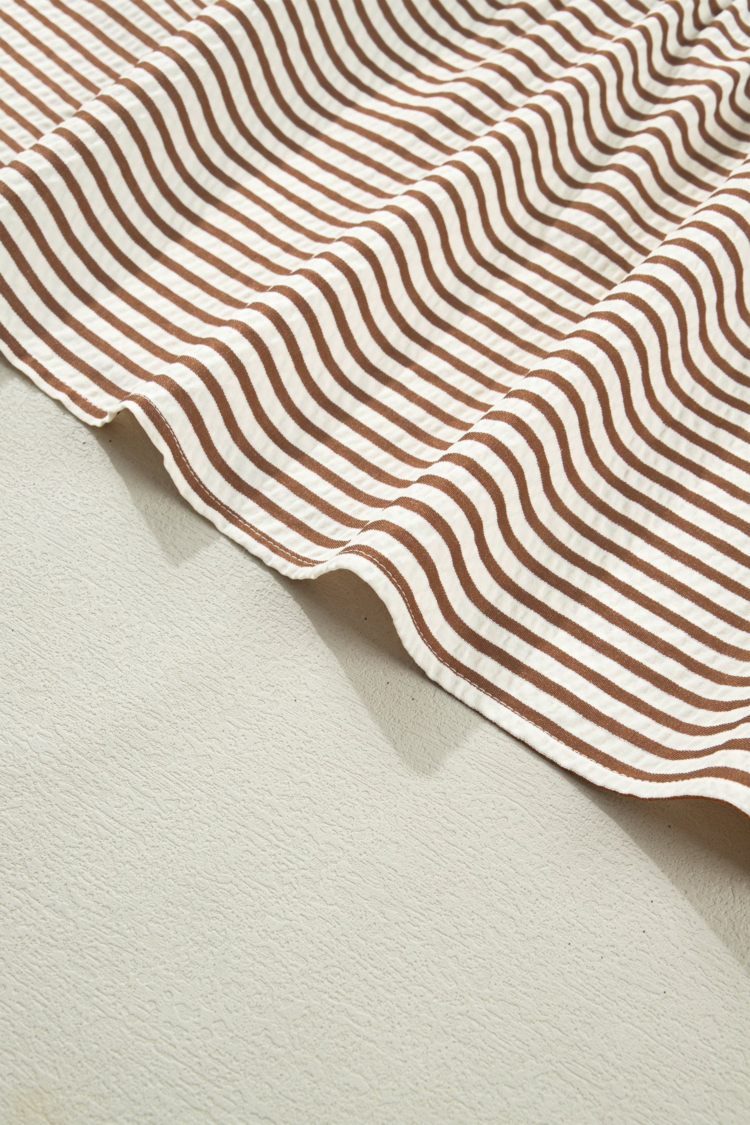 Brown-and-cream striped dress with rounded hem and stitched trim
