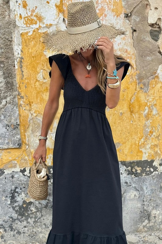 Black maxi dress with V-neck smocked bodice, flutter sleeves, and tiered hem.