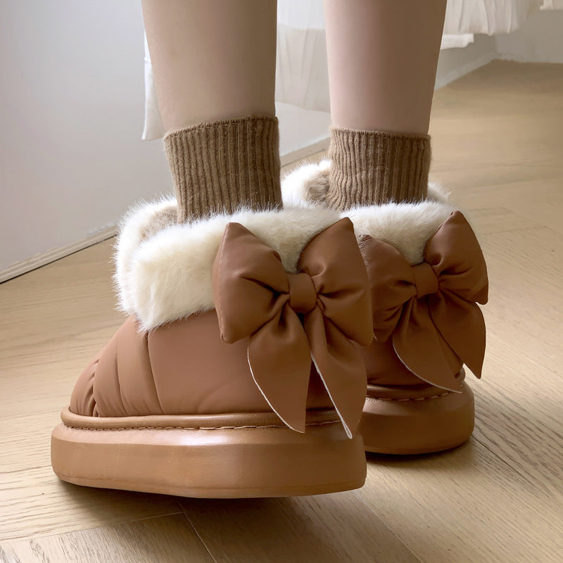 Tan winter ankle boots with faux fur trim and large ribbon bow, thick rubber sole