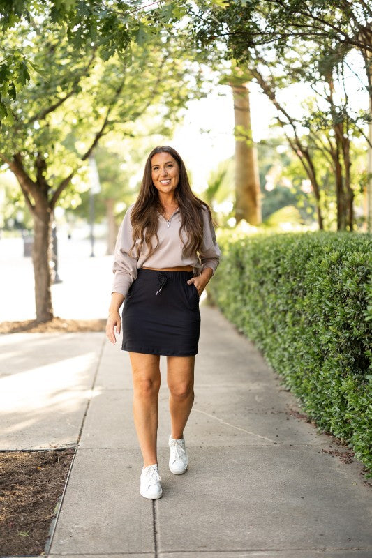 Black jogger skirt with drawstring waist and side pockets, above-knee length
