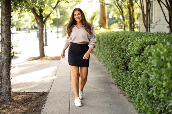 Black jogger skirt with drawstring waist and side pockets, above-knee length