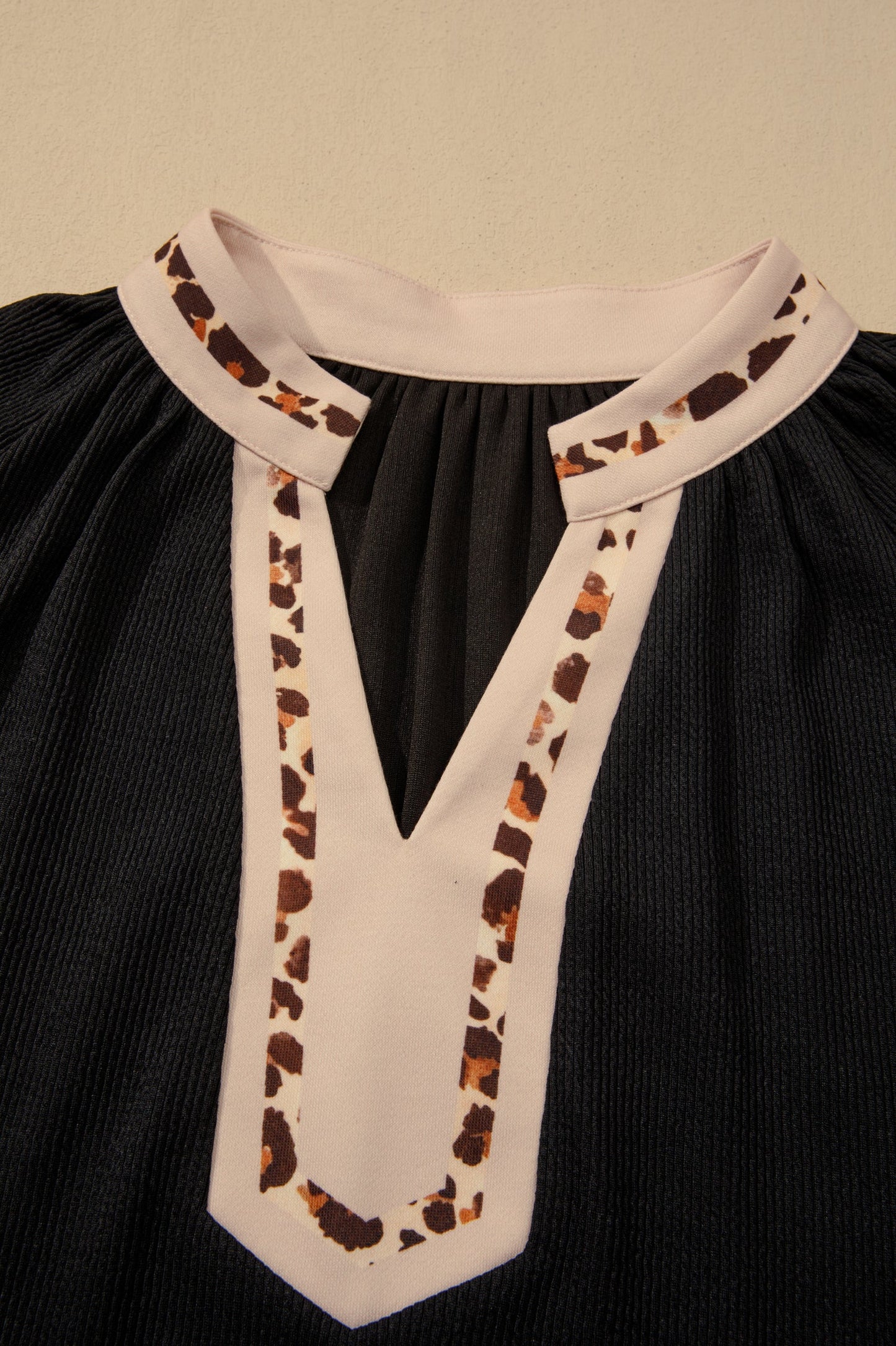 V-neck block trim neckline with beige leopard pattern on black ribbed dress