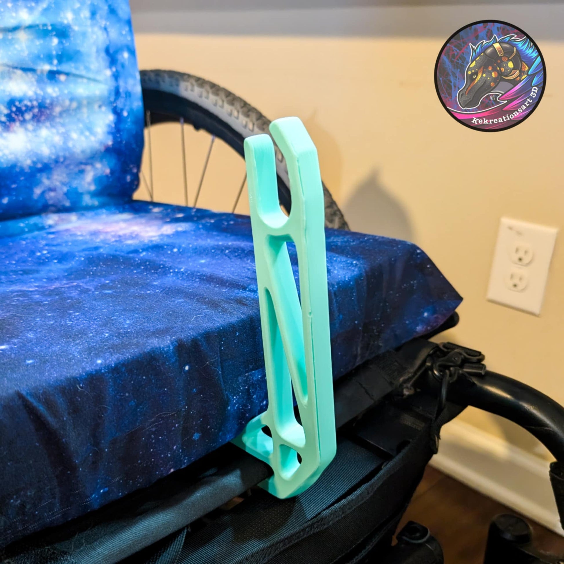 Light blue/teal wheelchair bag hook with U-shaped holder for hands-free carrying