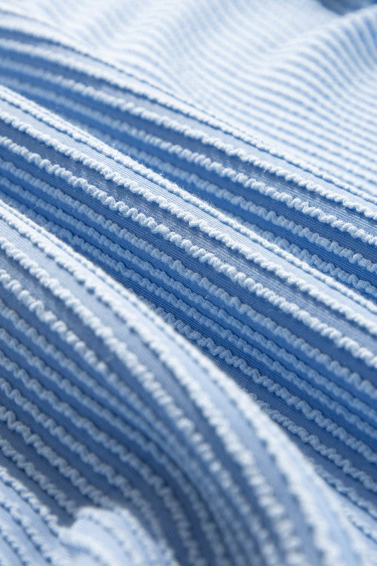 Blue corded fabric close-up with vertical striped texture