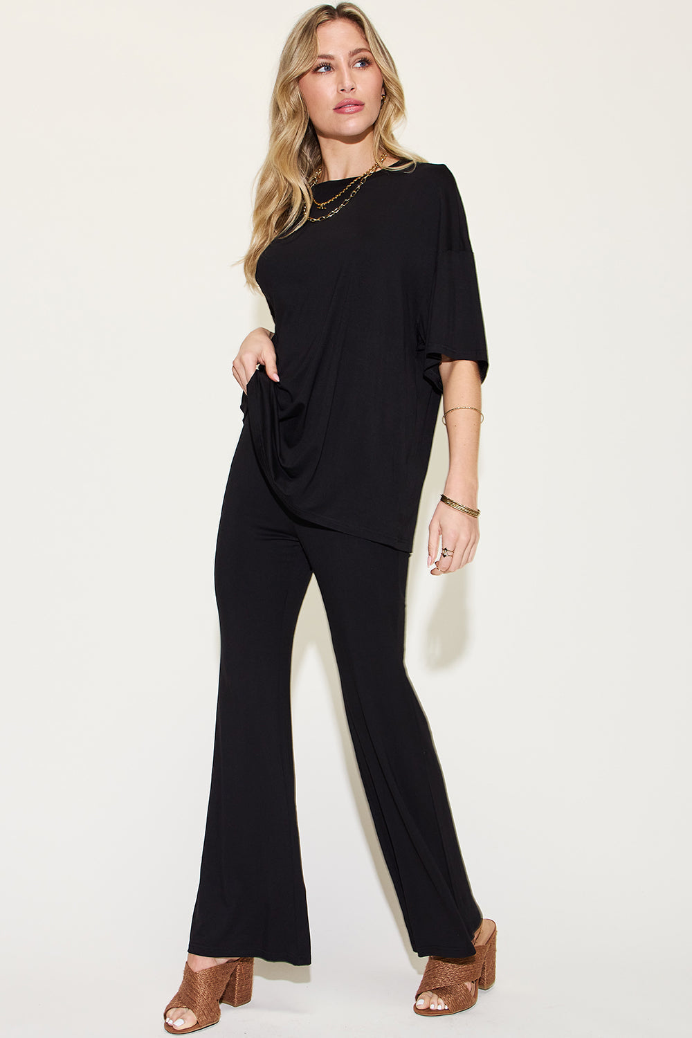 Black drop-shoulder t-shirt and flare pants set with draped front and wide-leg hems