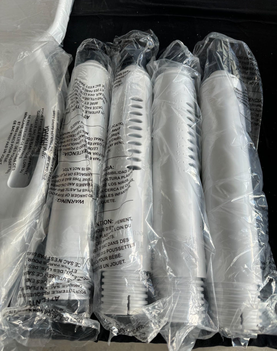 Wrapped shower chair leg components in protective plastic, white adjustable parts
