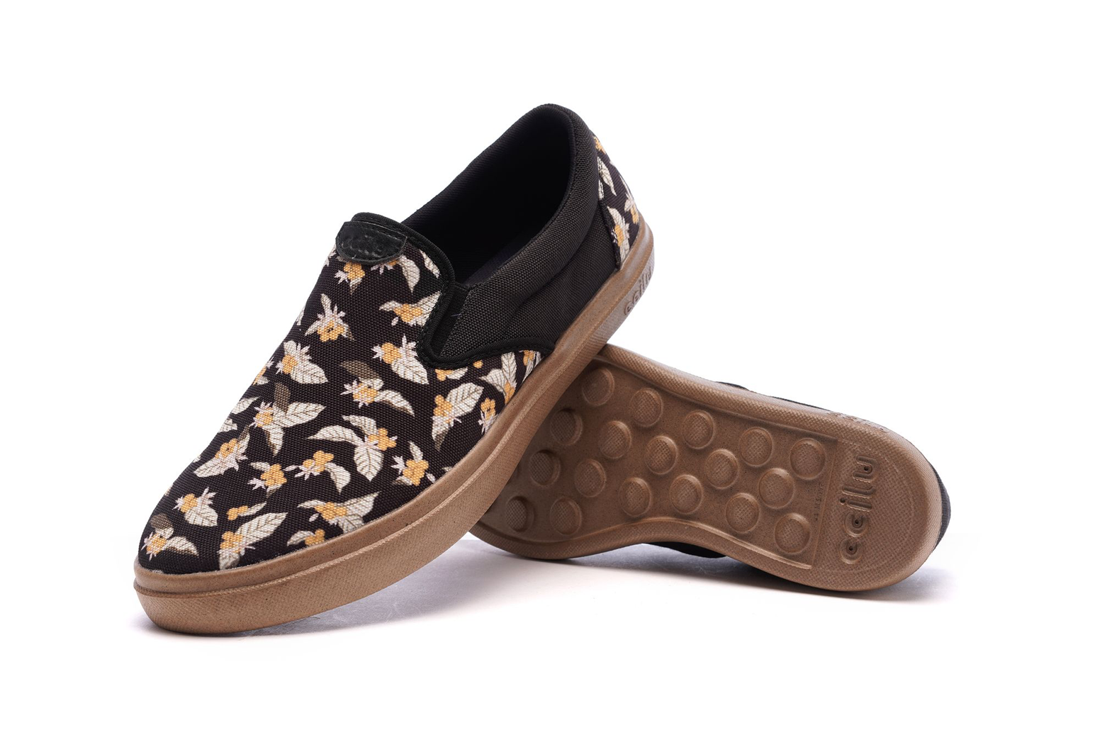 Men's slip-on sneakers with floral fabric upper, black collar, and tan sole