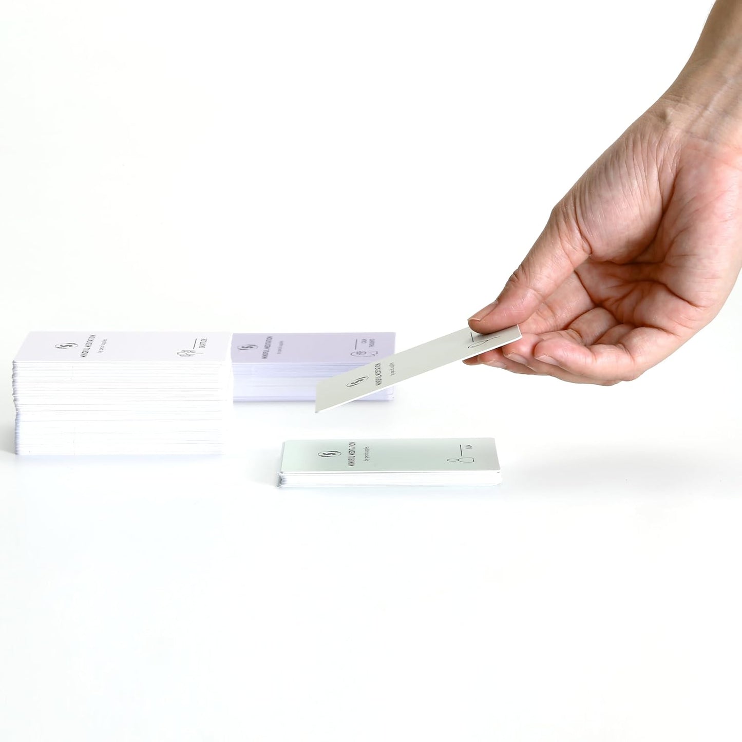 Mindfulness meditation cards fanned out as a hand selects one card.