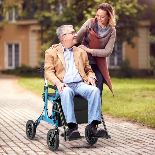 Woman pushing an elderly man in a blue and black rollator on a paved path with greenery in the background.