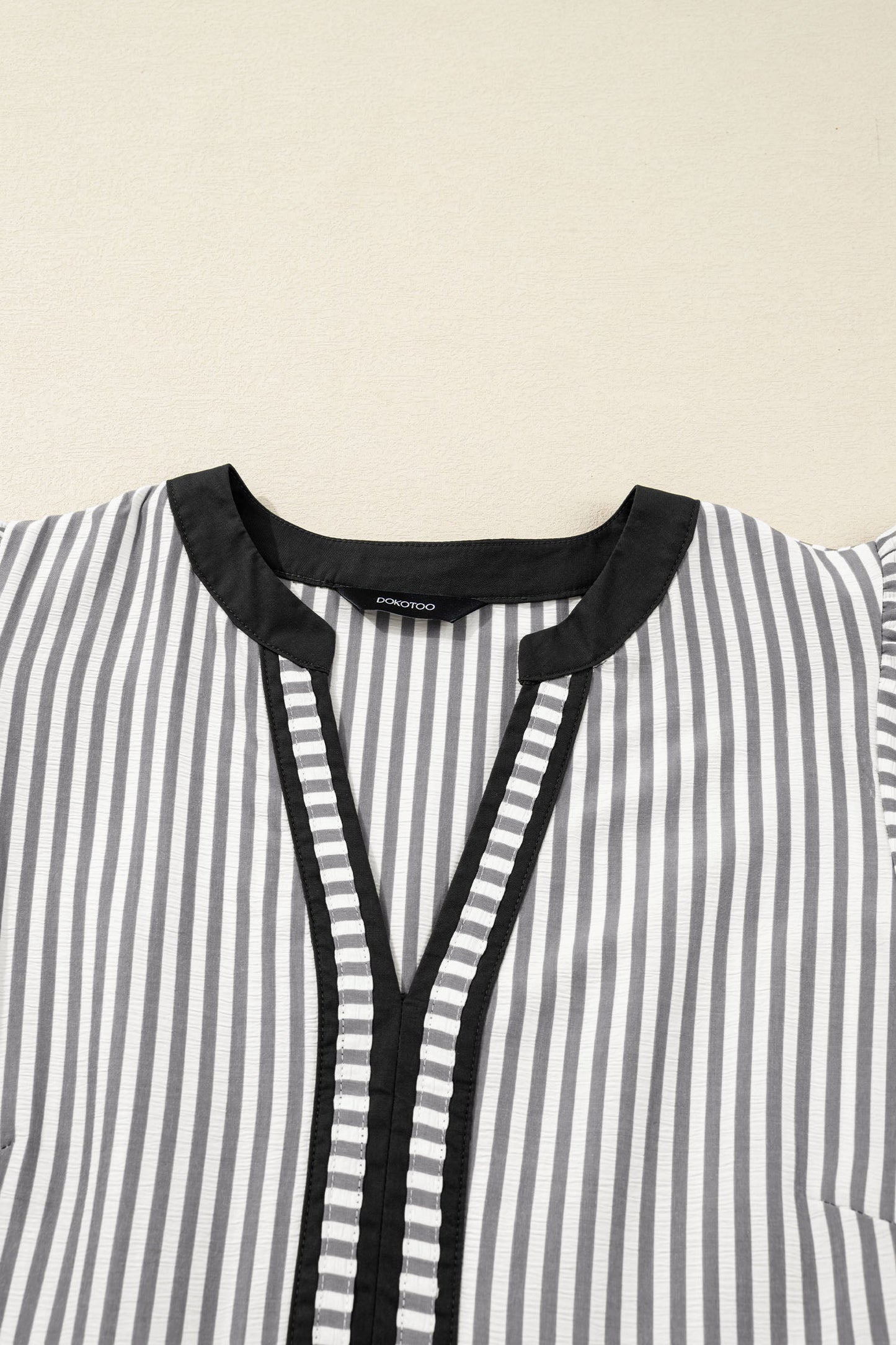 Striped V-neck dress with black trim and tassel-look placket