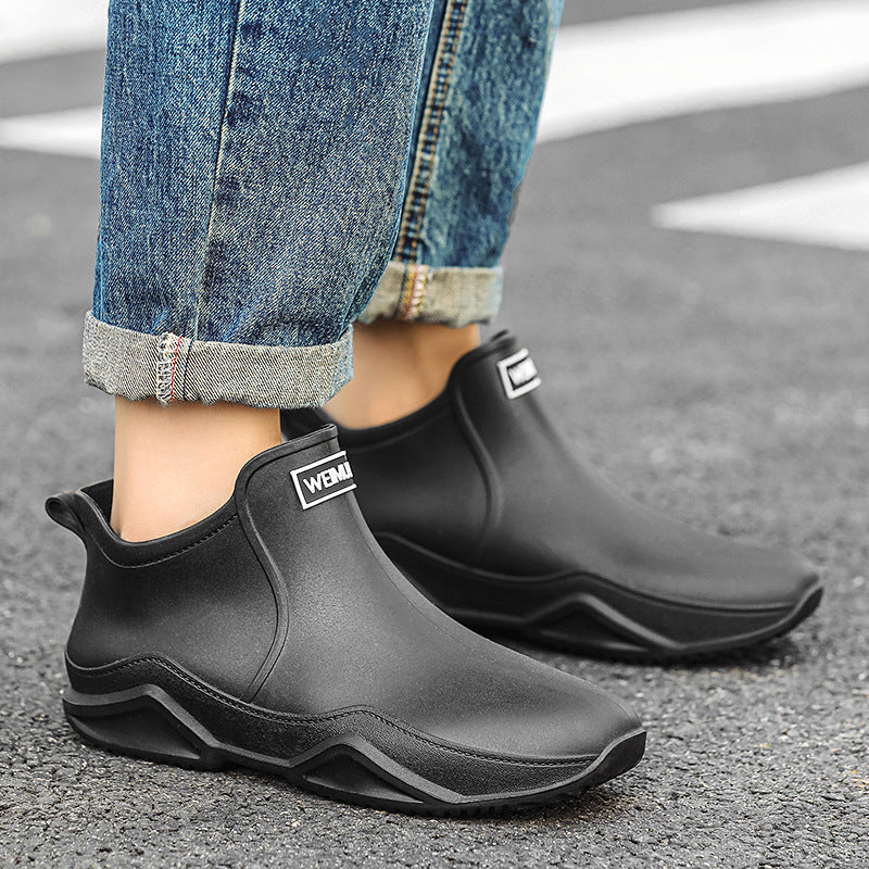 Men's short rain boots in black with sculpted sole and logo patch on upper