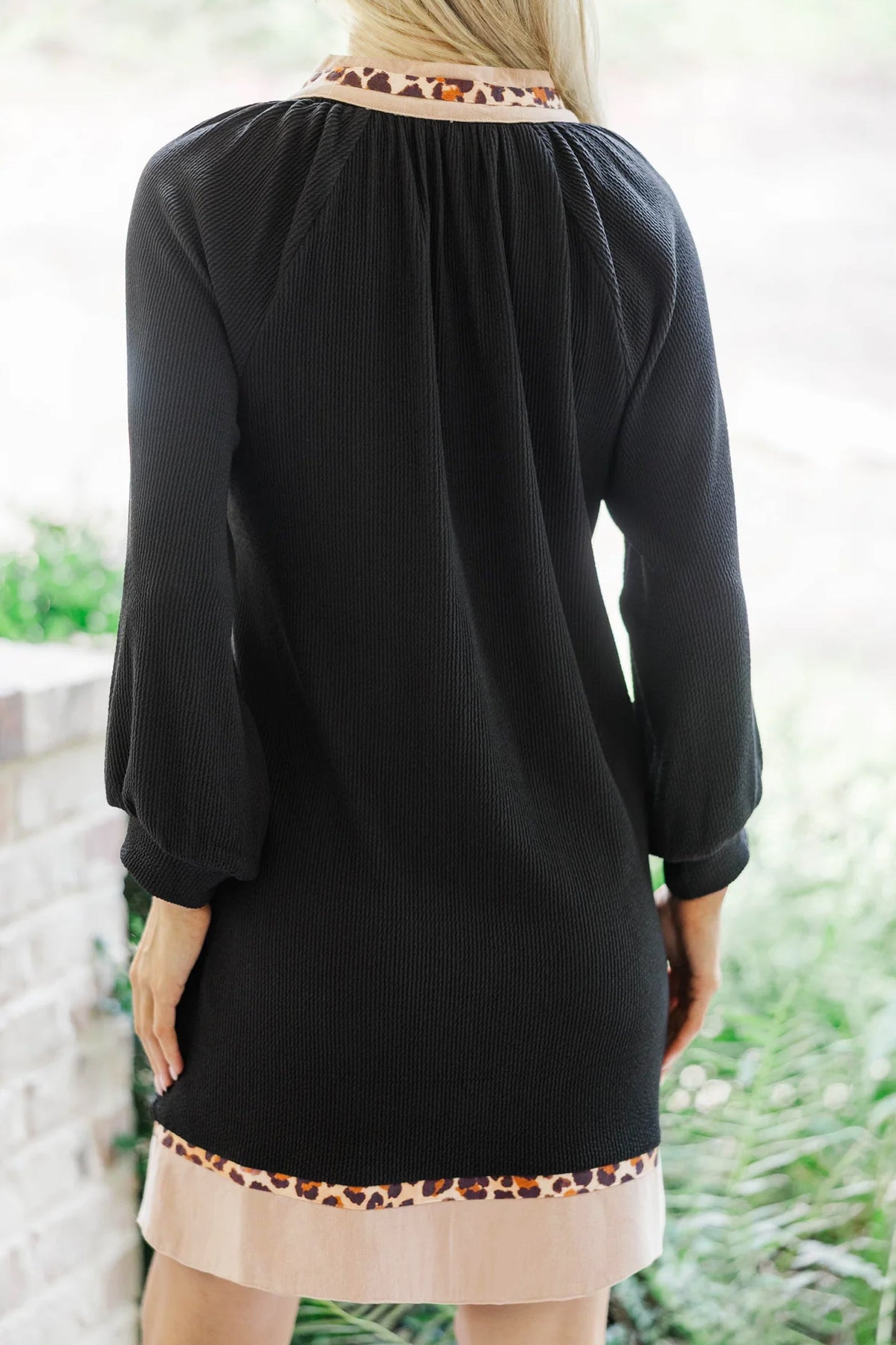 Black PLUS dress back view with gathered yoke and cream hem border trim