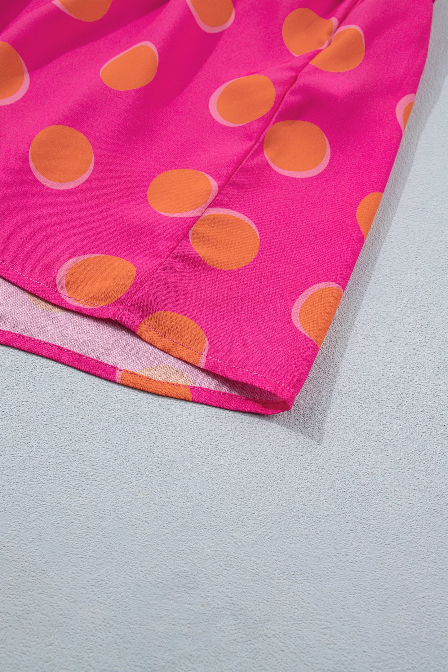 Rose midi dress hem with orange oval polka dots and smocked waist seam