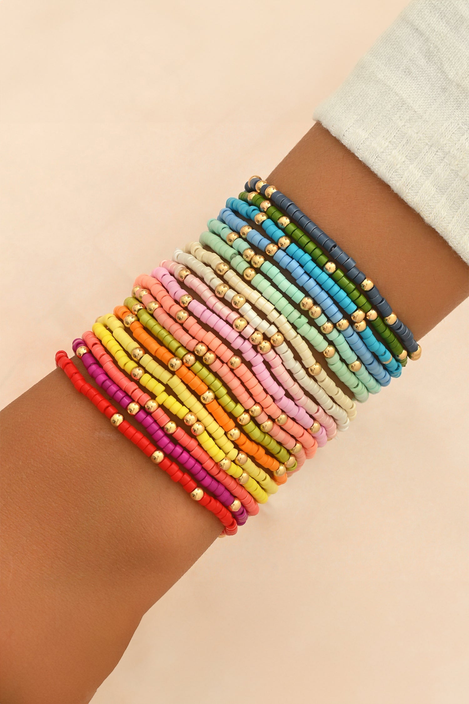 Beaded stretch bracelet set stacked on wrist, multicolor beads with gold-tone accents