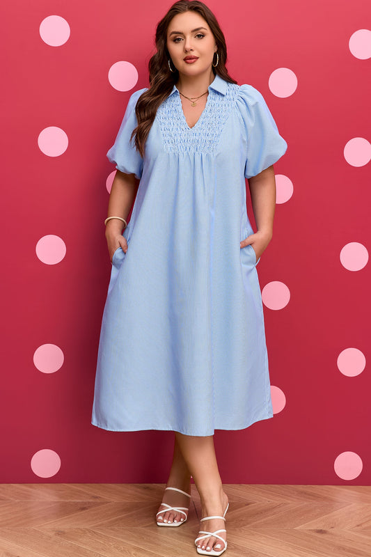 Plus-size light blue striped midi dress with V-neck, puff sleeves, and gathered yoke.