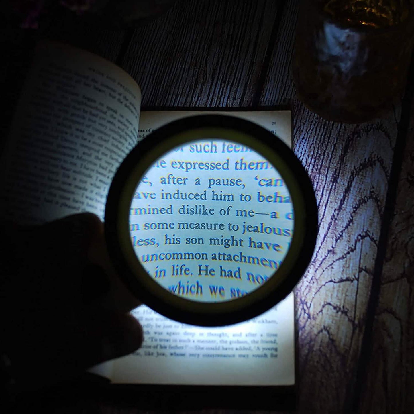Handheld magnifying glass with 12 LEDs, close-up of illuminated lens over book page