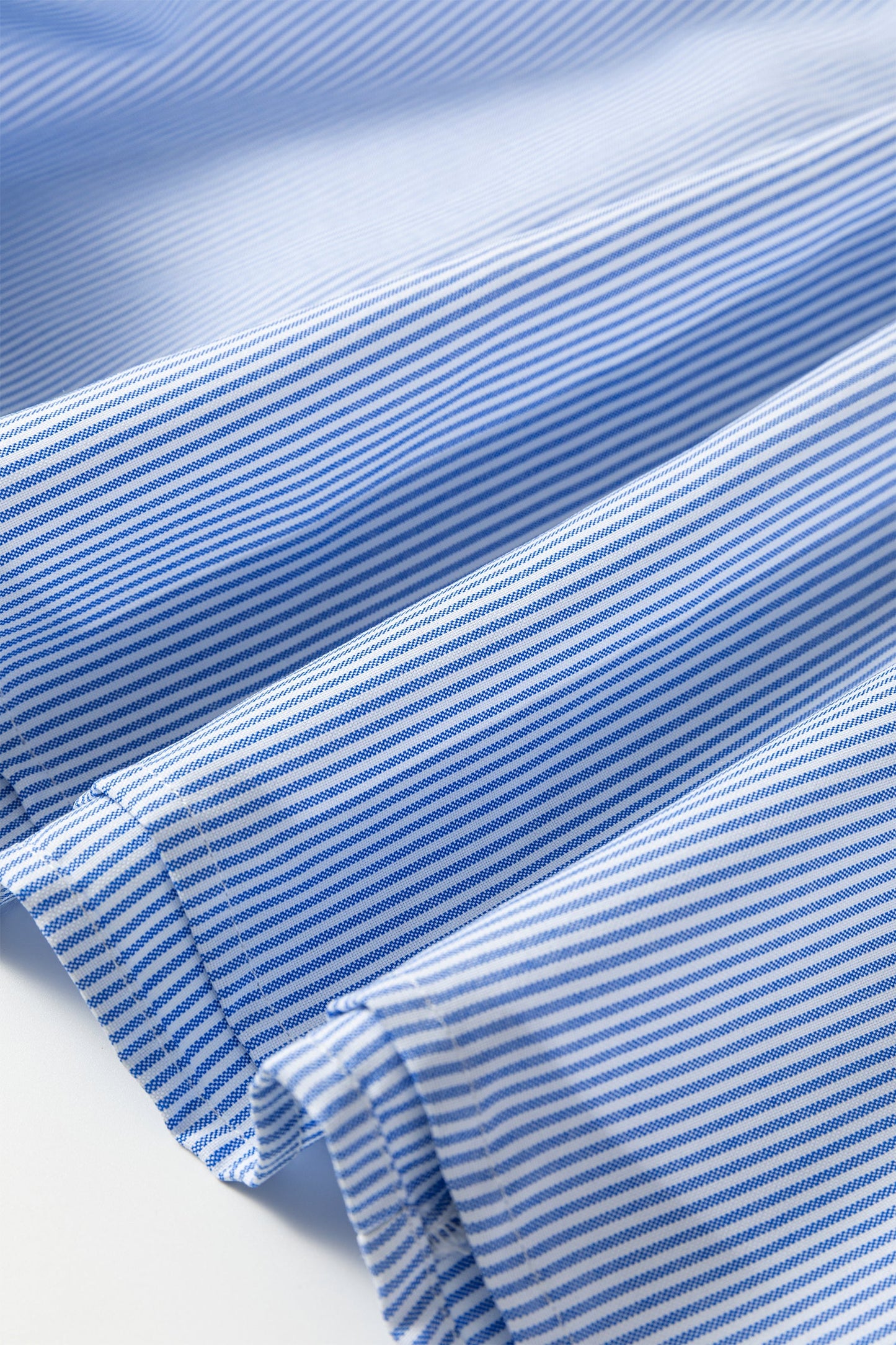 Light blue striped midi dress fabric with gathered hem and ruffle trim detail.