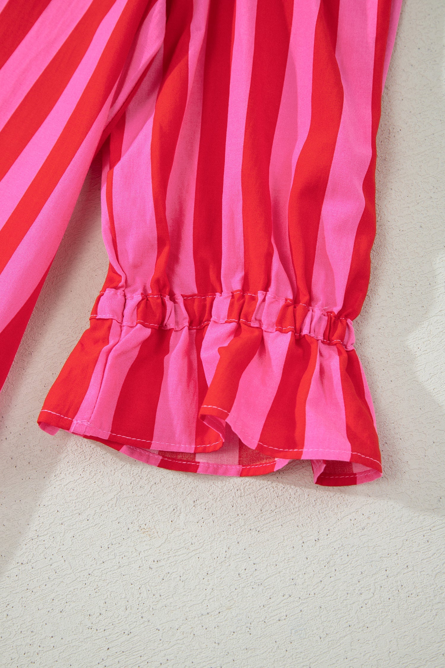 Pink and red striped mini dress with gathered sleeve cuffs and ruffled hem