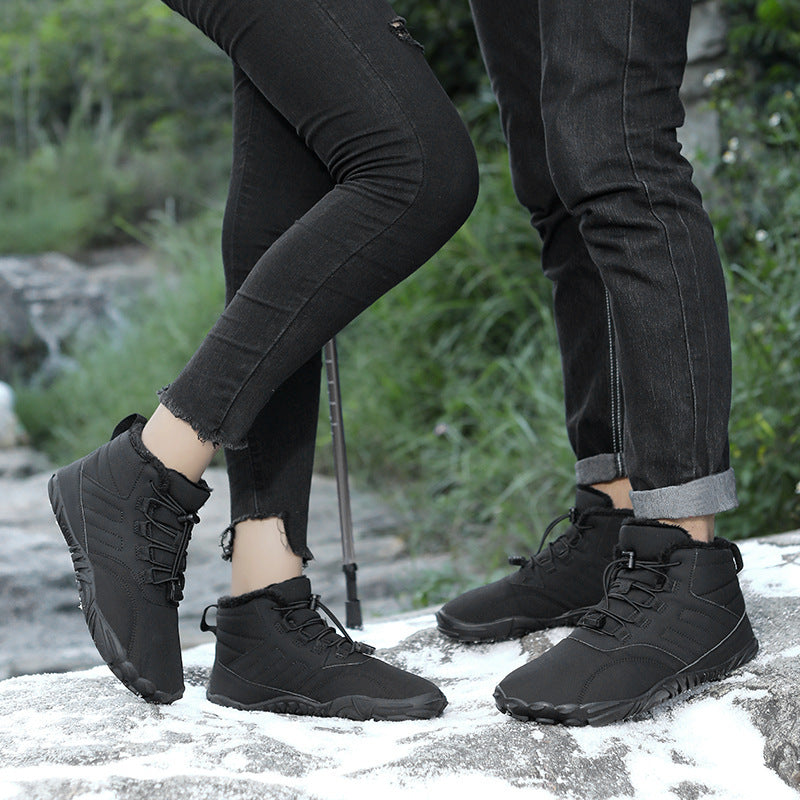 Black winter slip-on boots with lace-up front and thick sole, worn outdoors in snow.