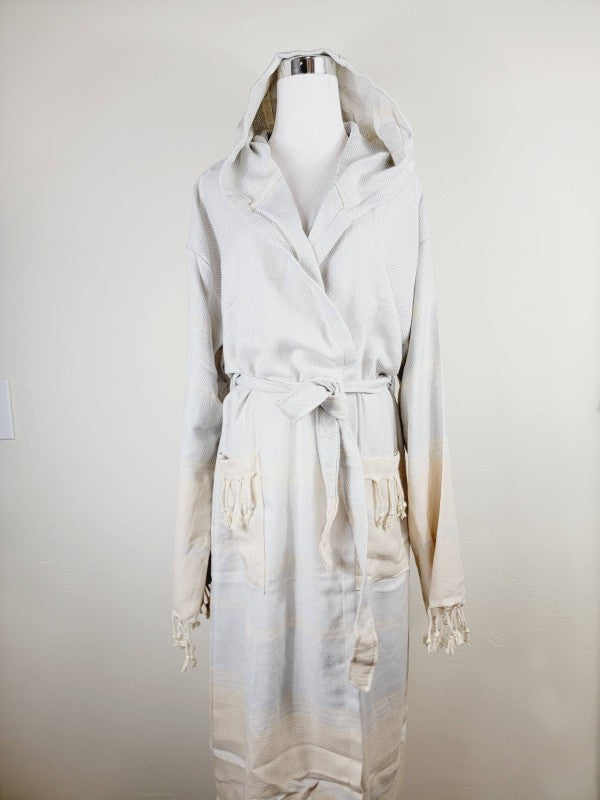 Off-white hooded robe with tie belt and patch pockets, tassel-trim cuffs