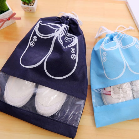 Navy blue drawstring shoe storage bag with white shoe icon and clear bottom panel.