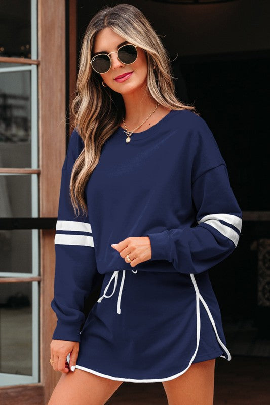 Navy pullover sweatshirt with white striped cuffs and matching mini skirt.
