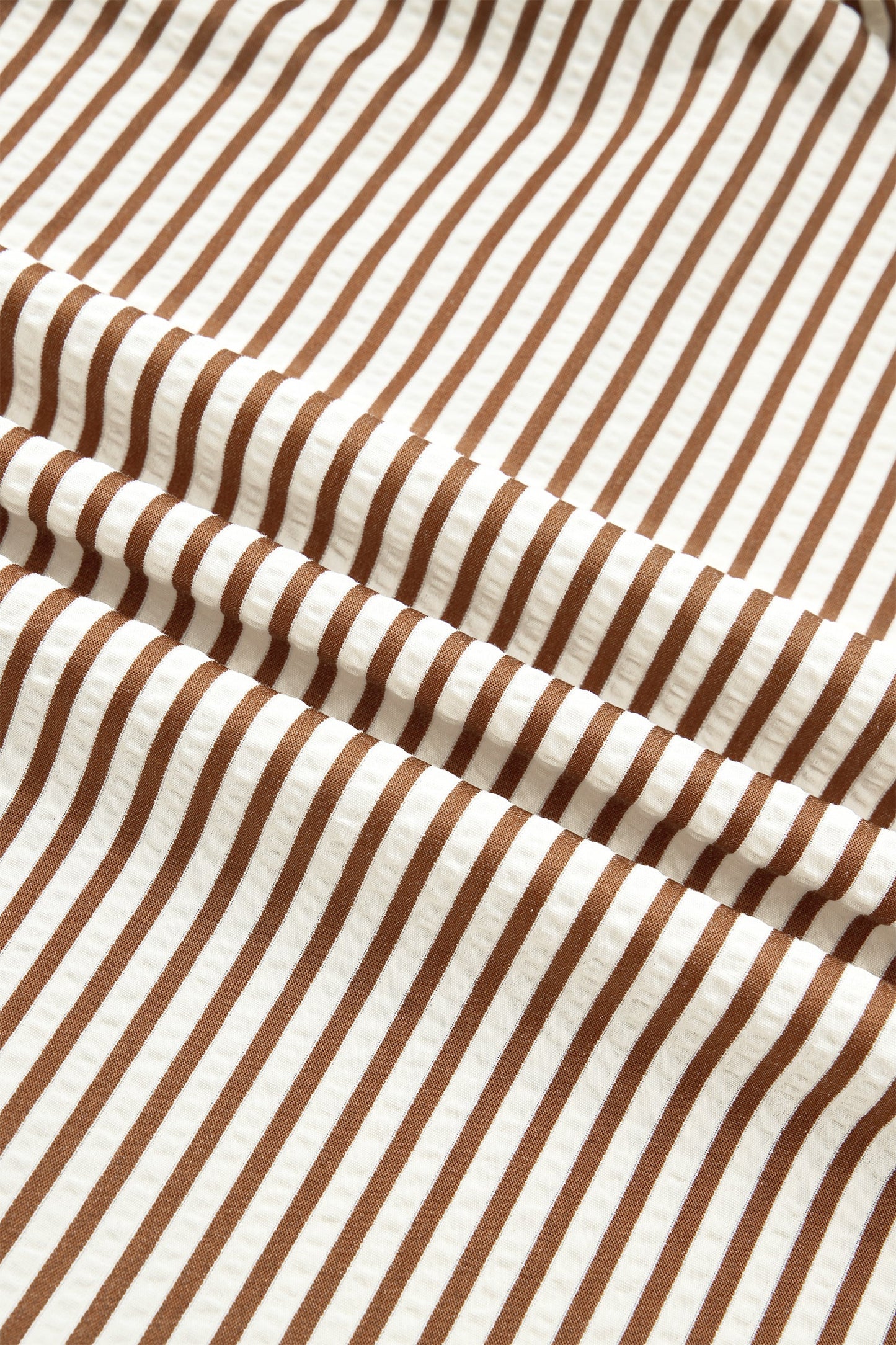 Brown-and-cream striped dress fabric with dense vertical stripe pattern
