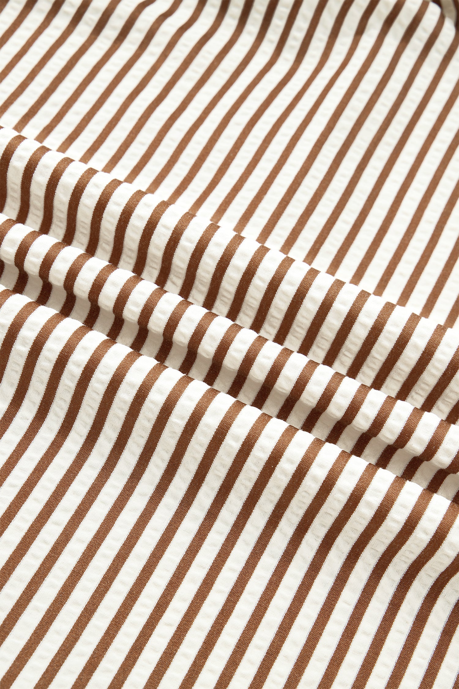 Brown-and-cream striped dress fabric with dense vertical stripe pattern