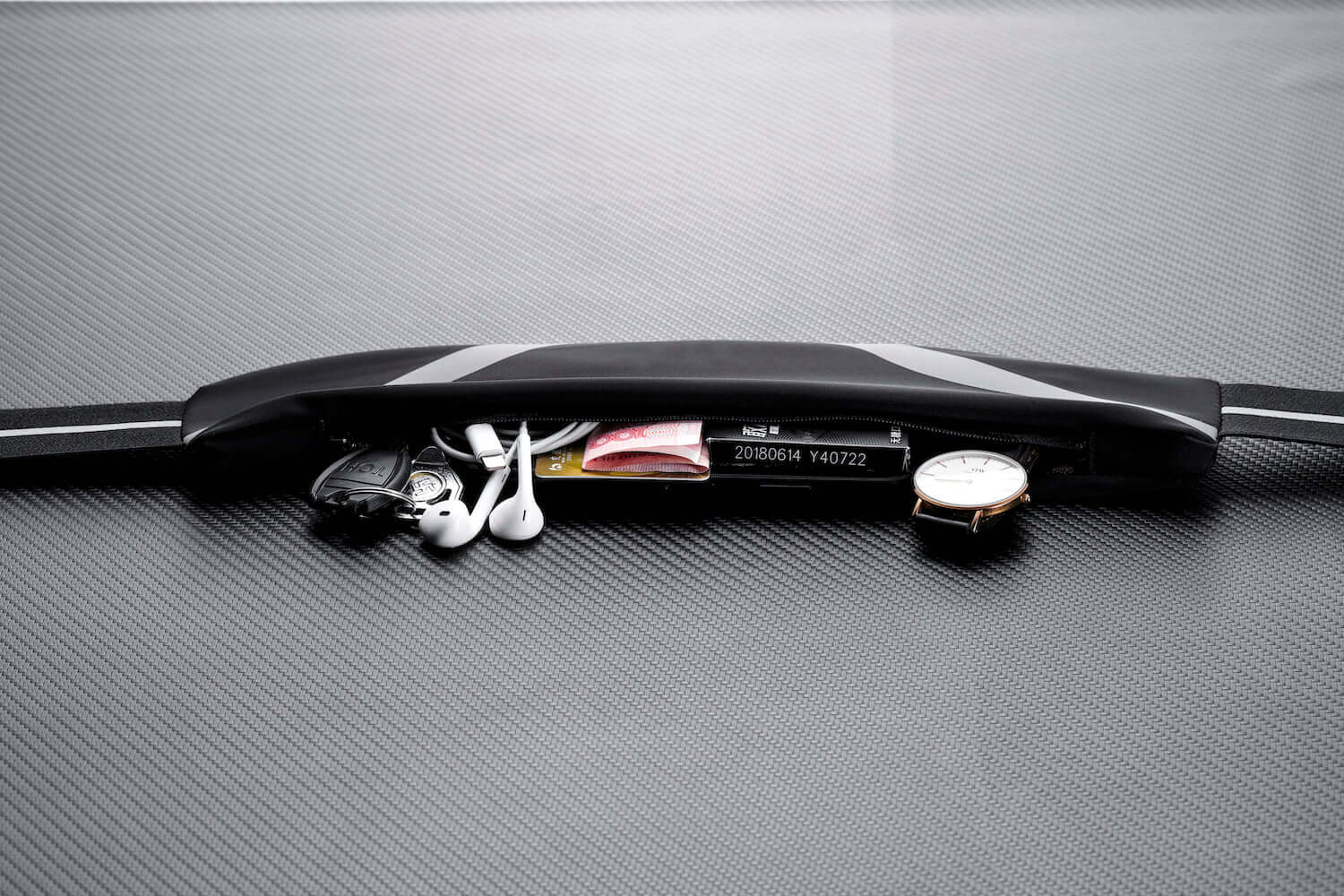 Water-resistant sport waist pack belt, black with reflective strip and zip compartment.